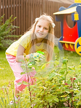 Girl sprays plants in the garden photo