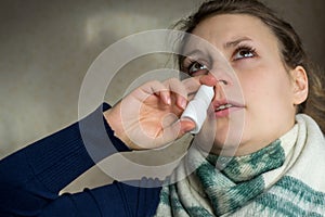 Sick girl sprays the spray from runny nose into the nasal pass