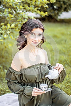 Girl in spring in a beautiful dress with blooming lilacs