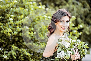 Girl in spring in a beautiful dress with blooming lilacs