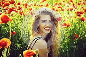 Girl on in spring field of poppy. Smiling face of spring girls. Happy young woman.