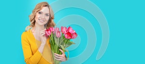 Girl with spring tulips flowers. happy young woman with spring flowers on blue background. Woman isolated face portrait
