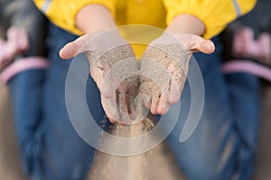 Girl sprinkles sand through her fingers