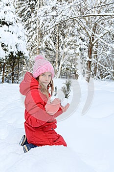 Girl with a spruce branch in the winter forest