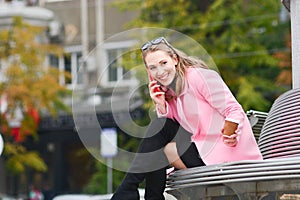 Girl spying on someone, talking on the phone and drinking coffee