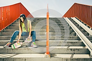 Girl on stairs with skateboard.