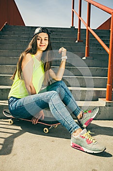 Girl on stairs with skateboard.