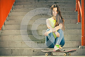 Girl on stairs with skateboard.