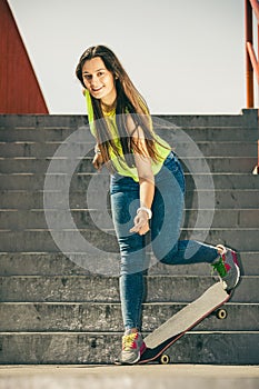 Girl on stairs with skateboard.