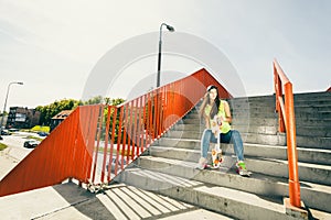 Girl on stairs with skateboard.