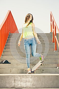 Girl on stairs with skateboard.