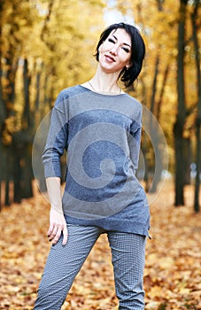 Girl stand in autumn park with yellow trees, fall season