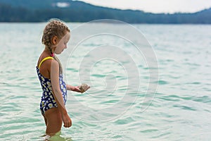 Girl standing on the beach and looks into the distance