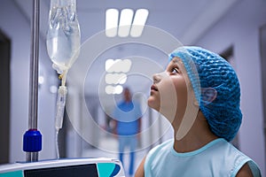 Girl standing in corridor and looking at iv drip