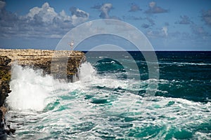 Girl standing on the edge of Devil`s Bridge bay - Caribbean tropical sea - Antigua and Barbuda. Concept of freedom an