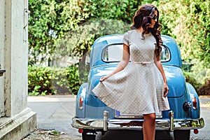 Girl standing in front of the classic blue car