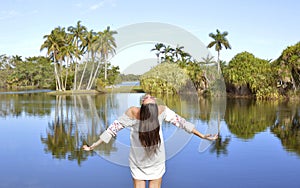 A girl standing a front of the lake