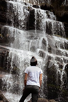 Girl standing in front of a waterfall