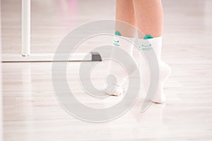 Girl standing on her toes gymnastics with white socks