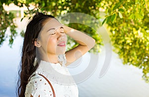 Girl standing by the lake and enjoying the summer breeze photo