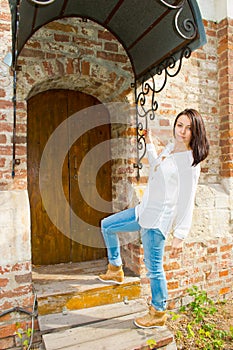 Girl standing at the old wooden door