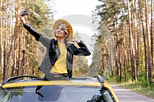 Girl Standing out of Car Sunroof Summer Road Trip