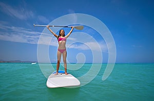 Girl standing on paddle surf board SUP