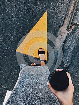 The girl is standing at a pedestrian crossing. View from above. Vertical shot.