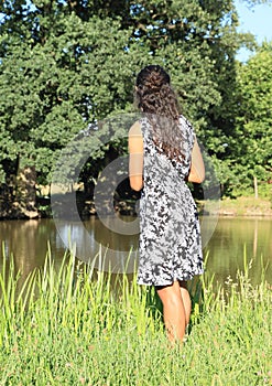 Girl standing by pond