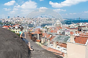 Girl standing on the roof and looking at city Istanbul