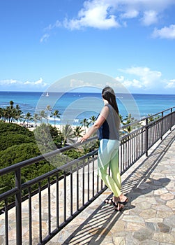 A girl standing on the roof top above the ocean