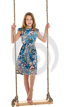 Girl standing on rope swing.Portrait of happy preteen child