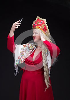 Girl standing in Russian traditional costume with mobile phone