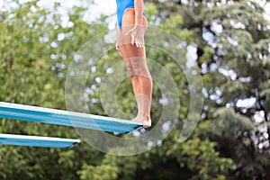 Girl standing on a springboard, preparing to dive photo