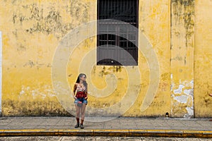 Girl standing on a street wall in Valladolid, Mexico