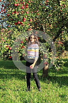 Girl standing under apple tree