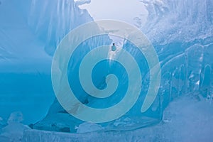 Girl standing on the wave of blue ice blocks at dusk. lake Baikal