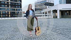 Girl stands with classical guitar in square