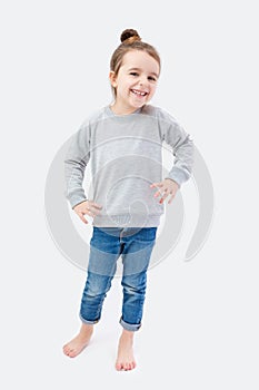 A girl stands on gray background.