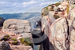 A girl stands on Kjerag stone