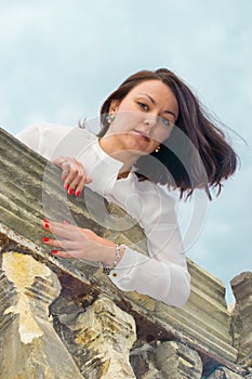 A girl stands on massive stone balcony