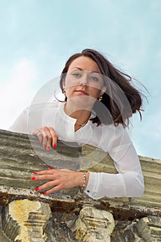 A girl stands on massive stone balcony