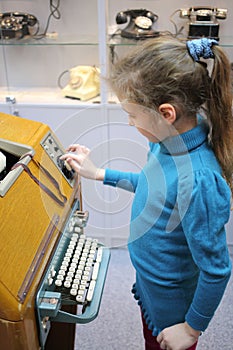 Girl stands near vintage telegraph devices in the photo