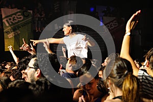 A girl stands over the crowd in a concert at Razzmatazz discotheque