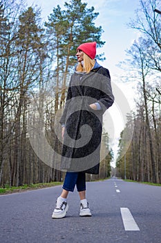 The girl stands on the road in the forest