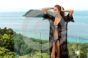 Girl stands on the seashore overlooking the mountains near the pool