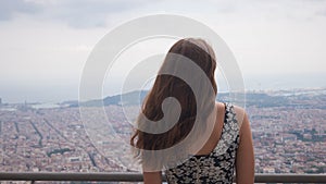 Girl staying on observation deck. Barcelona city aerial view. City overview.