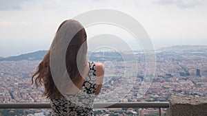 Girl staying on observation deck. Barcelona city aerial view. City overview. Breathtaking view