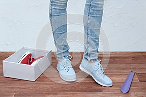 Girl in the store trying on a pair of blue sneakers. Close-up