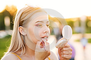 Girl straightens makeup on street